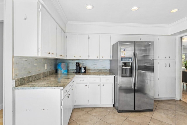 kitchen with white cabinets, decorative backsplash, ornamental molding, and stainless steel refrigerator with ice dispenser