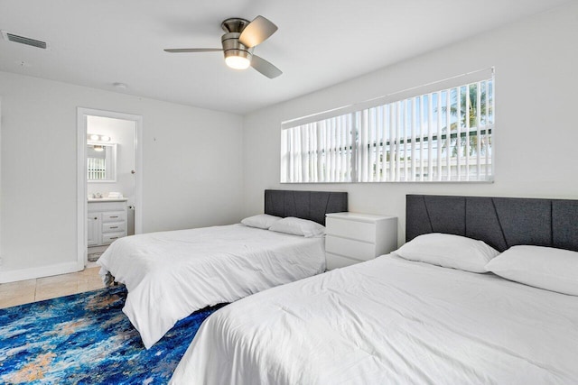 bedroom with tile patterned flooring, ceiling fan, and connected bathroom