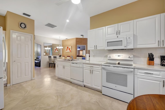 kitchen featuring white appliances, ceiling fan with notable chandelier, tasteful backsplash, decorative light fixtures, and white cabinetry