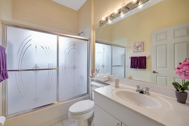 full bathroom featuring combined bath / shower with glass door, vanity, toilet, and tile patterned flooring