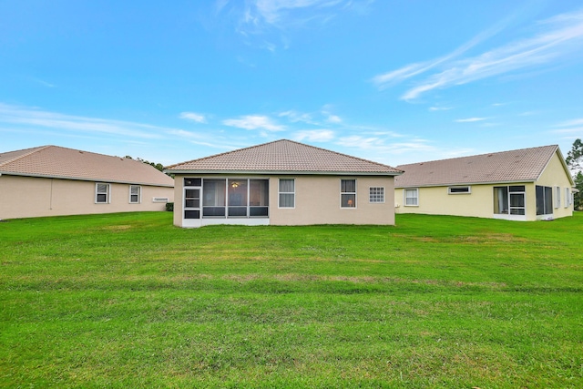 back of house with a yard and a sunroom