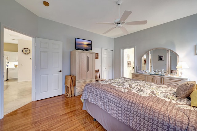 bedroom featuring ceiling fan, light hardwood / wood-style floors, white refrigerator, and a closet