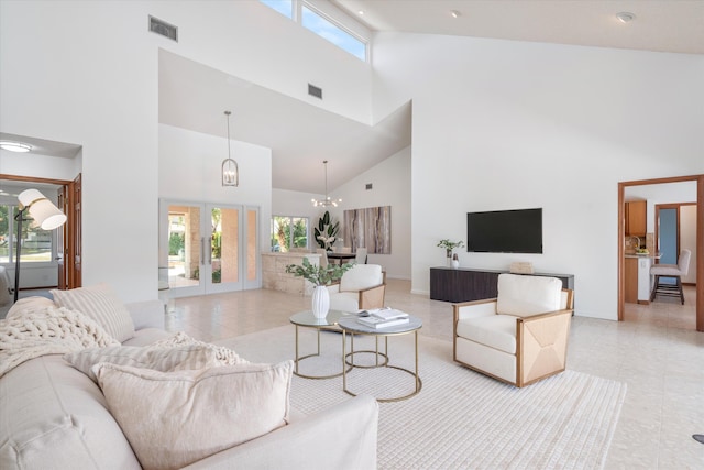 tiled living room featuring a chandelier, high vaulted ceiling, and french doors