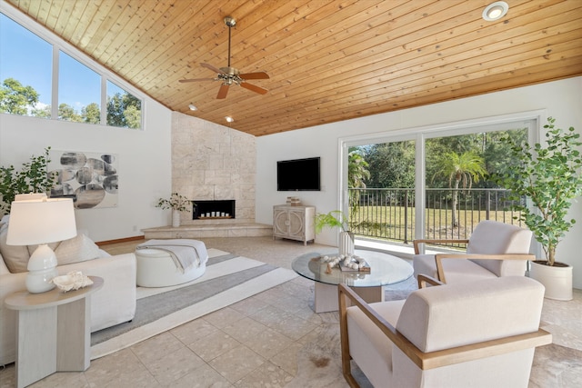 living room with a fireplace, a wealth of natural light, wooden ceiling, and ceiling fan