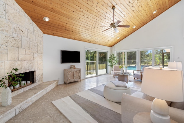 living room featuring ceiling fan, wood ceiling, high vaulted ceiling, and a tiled fireplace