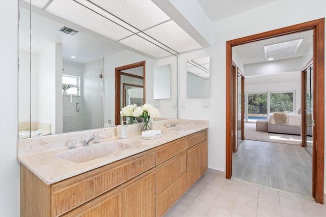 bathroom featuring hardwood / wood-style flooring, vanity, and a shower with door