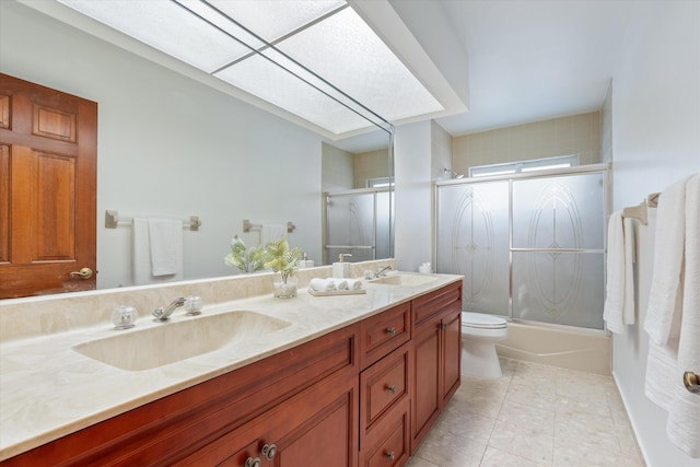 full bathroom featuring tile patterned flooring, vanity, toilet, and shower / bath combination with glass door