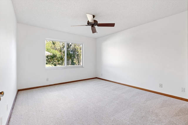 carpeted empty room with ceiling fan and a textured ceiling