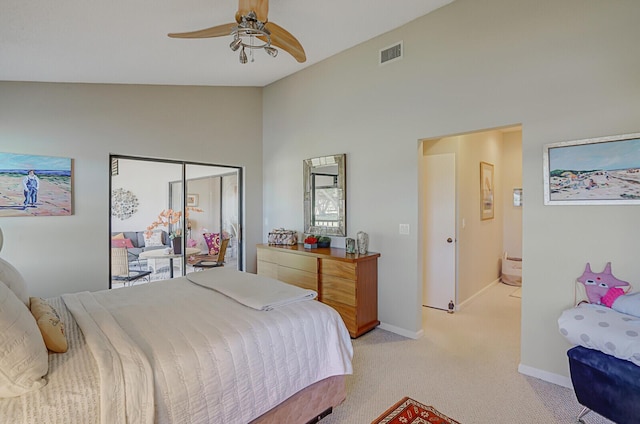 bedroom featuring ceiling fan, light colored carpet, high vaulted ceiling, and ensuite bath