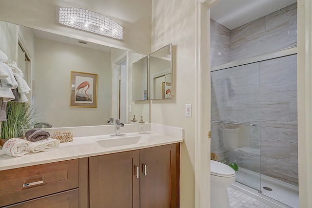 bathroom with tile patterned floors, vanity, toilet, and a shower with shower door