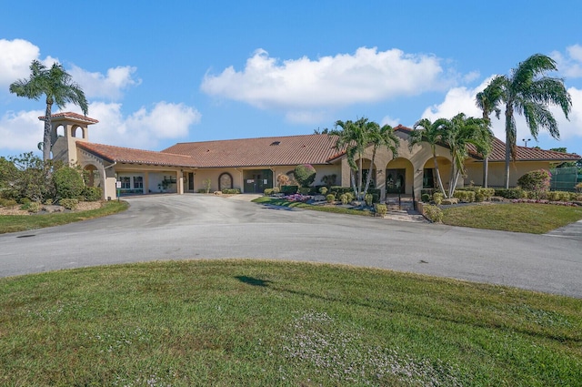 mediterranean / spanish-style home with a front lawn