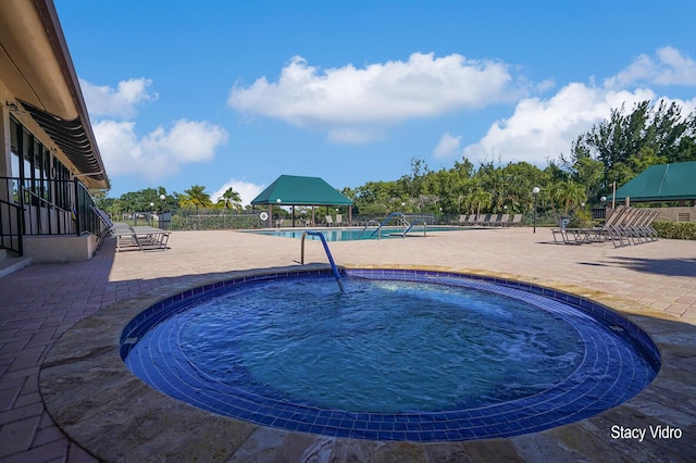 view of pool featuring a community hot tub and a patio