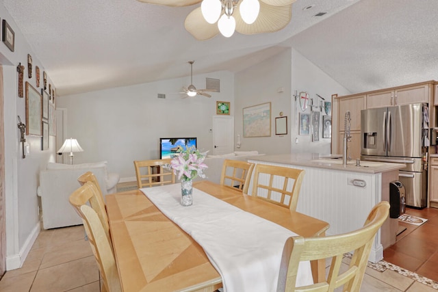 tiled dining room featuring ceiling fan, a textured ceiling, and vaulted ceiling