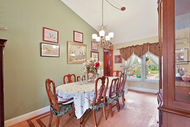 dining space featuring a chandelier, light hardwood / wood-style flooring, and vaulted ceiling