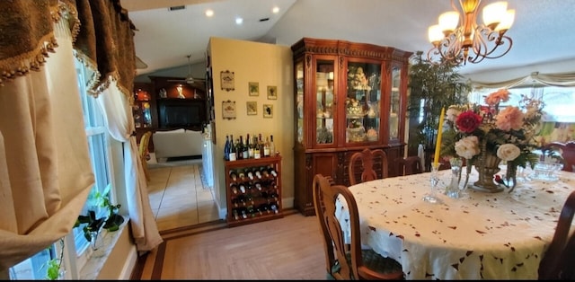 dining space featuring light tile patterned floors, lofted ceiling, and a notable chandelier