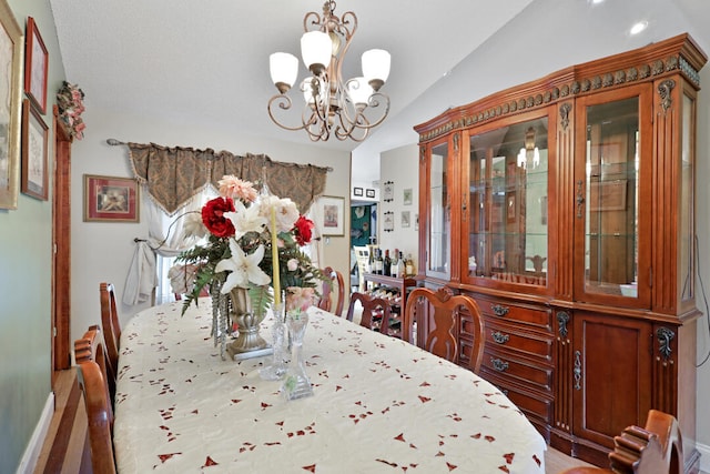 dining space featuring lofted ceiling and an inviting chandelier