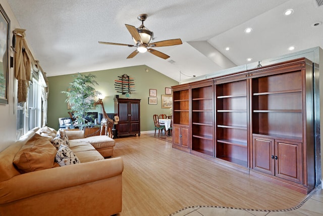 living room with ceiling fan, light hardwood / wood-style flooring, and vaulted ceiling