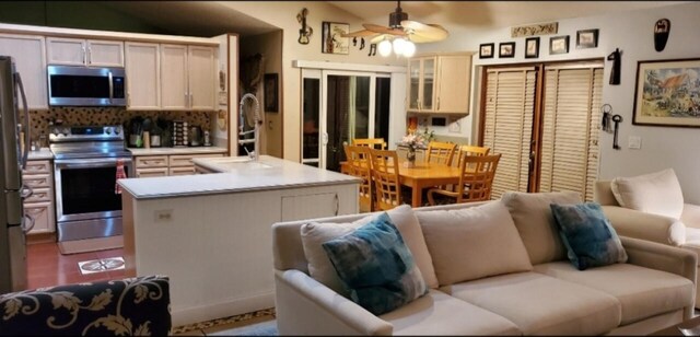 kitchen featuring ceiling fan, sink, a center island, stainless steel appliances, and vaulted ceiling