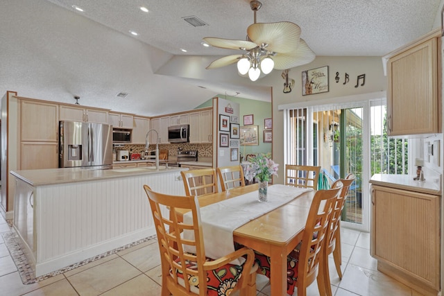 tiled dining room featuring a textured ceiling, high vaulted ceiling, ceiling fan, and sink