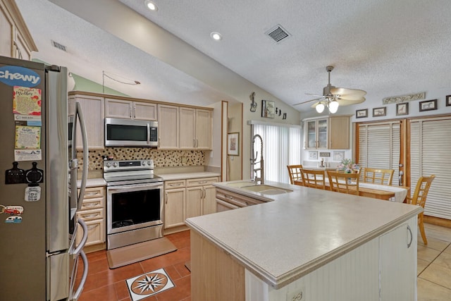 kitchen featuring a center island with sink, stainless steel appliances, vaulted ceiling, and sink