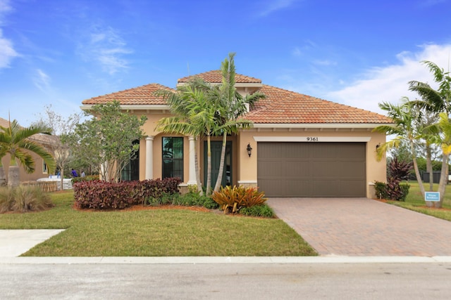 mediterranean / spanish home with a garage and a front yard