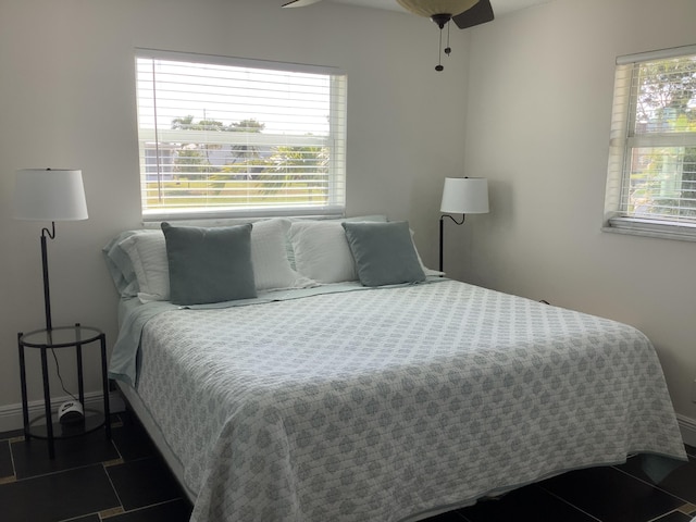 bedroom with dark tile patterned flooring and ceiling fan