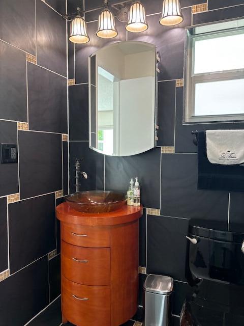 bathroom featuring tile walls and vanity