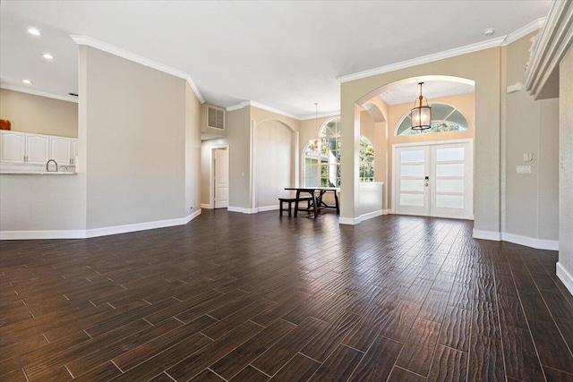 entryway featuring french doors, dark hardwood / wood-style flooring, an inviting chandelier, and ornamental molding