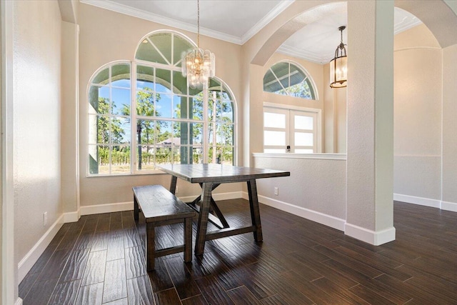 dining space with dark hardwood / wood-style floors, an inviting chandelier, and ornamental molding