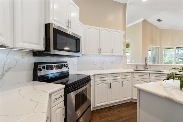 kitchen with white cabinets, appliances with stainless steel finishes, decorative backsplash, and dark wood-type flooring