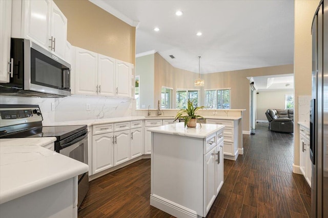 kitchen featuring white cabinets, pendant lighting, stainless steel appliances, and dark hardwood / wood-style floors