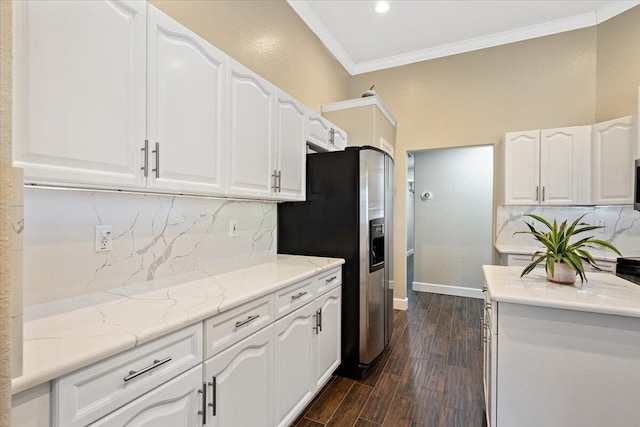 kitchen featuring dark wood-type flooring, tasteful backsplash, stainless steel fridge, crown molding, and white cabinets