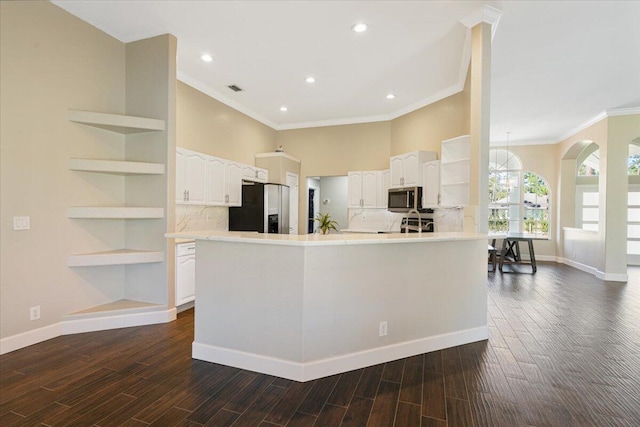 kitchen with backsplash, stainless steel appliances, crown molding, white cabinets, and dark hardwood / wood-style floors