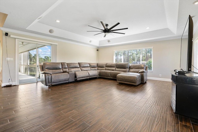 living room featuring a tray ceiling, ceiling fan, crown molding, and dark hardwood / wood-style floors