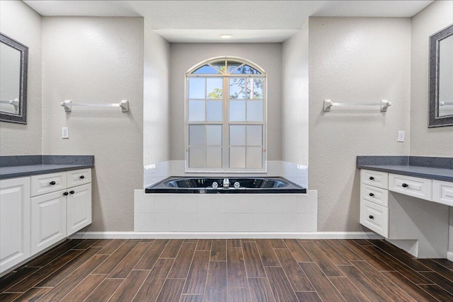 bathroom with a washtub, hardwood / wood-style floors, and vanity