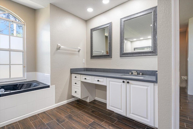 bathroom featuring a bathtub, vanity, and wood-type flooring