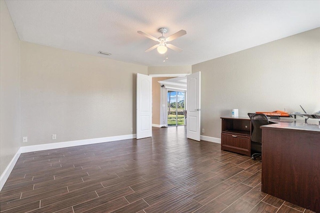 office space featuring a textured ceiling, ceiling fan, and dark wood-type flooring