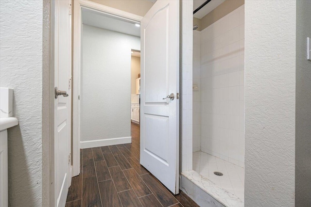 bathroom featuring tiled shower and wood-type flooring