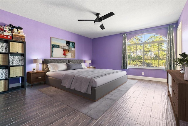 bedroom featuring a textured ceiling, ceiling fan, and dark wood-type flooring