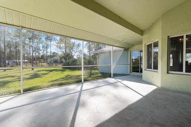 unfurnished sunroom featuring a healthy amount of sunlight and lofted ceiling