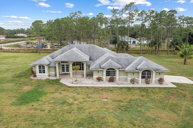 back of property with a yard and french doors