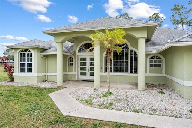 doorway to property featuring a lawn and french doors