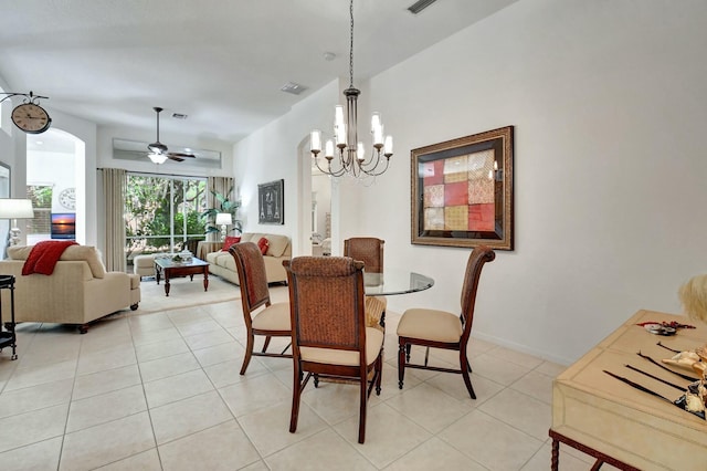 tiled dining room with ceiling fan with notable chandelier