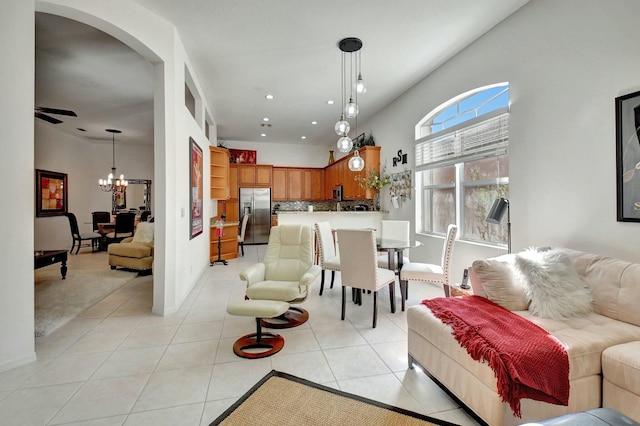 living room featuring ceiling fan with notable chandelier and light tile patterned flooring