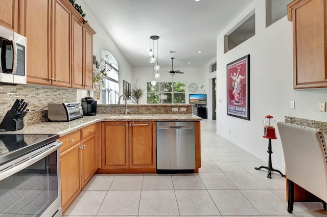 kitchen with ceiling fan, sink, stainless steel appliances, decorative light fixtures, and light tile patterned floors