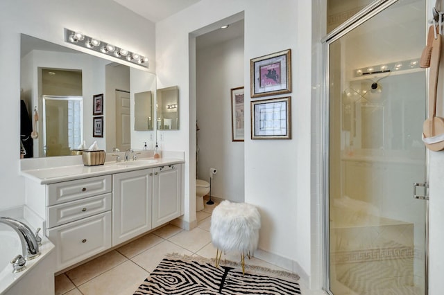 bathroom featuring tile patterned floors, toilet, vanity, and walk in shower