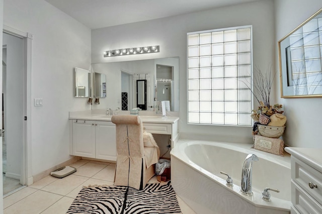 bathroom with a washtub, vanity, and tile patterned floors