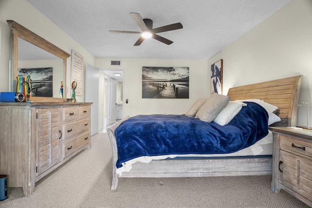 bedroom featuring a textured ceiling, ceiling fan, and light carpet