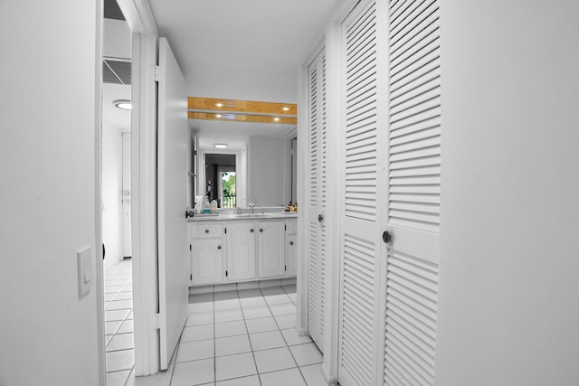 hallway featuring sink and light tile patterned floors