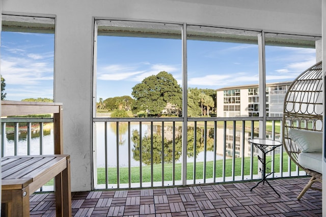 sunroom featuring a water view